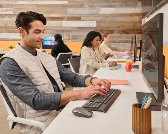 Several young professional people sitting at their desks smiling contently and working