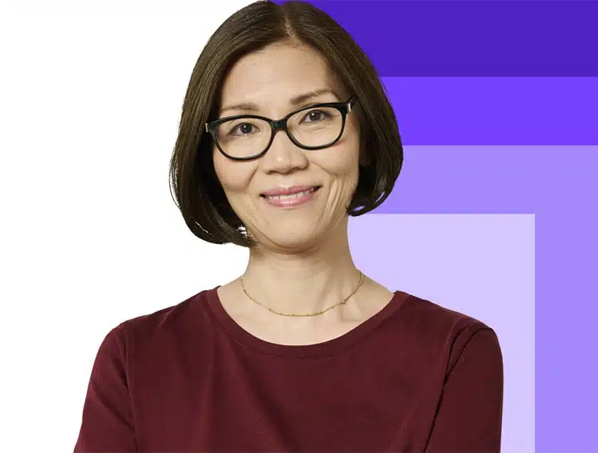 Woman with glasses smiling at the camera