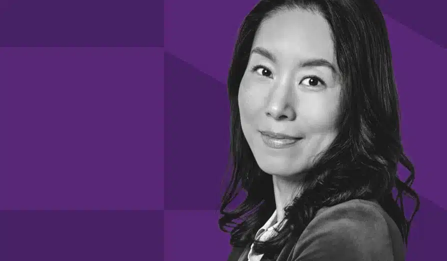Femme regardant l'objectif avec confiance sur un fond géométrique violet