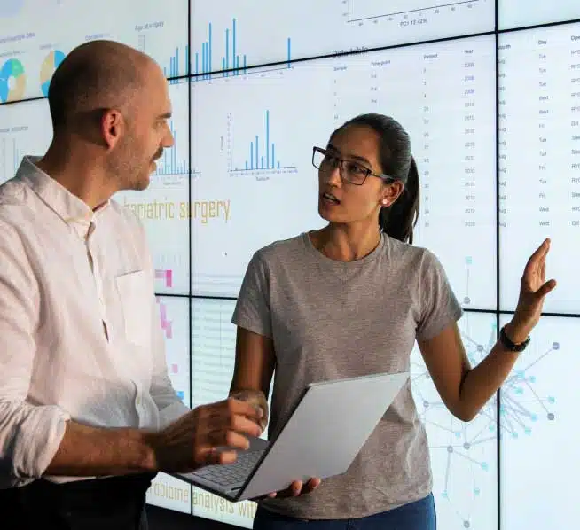 Male and female coworkers standing together and inspecting financial numbers
