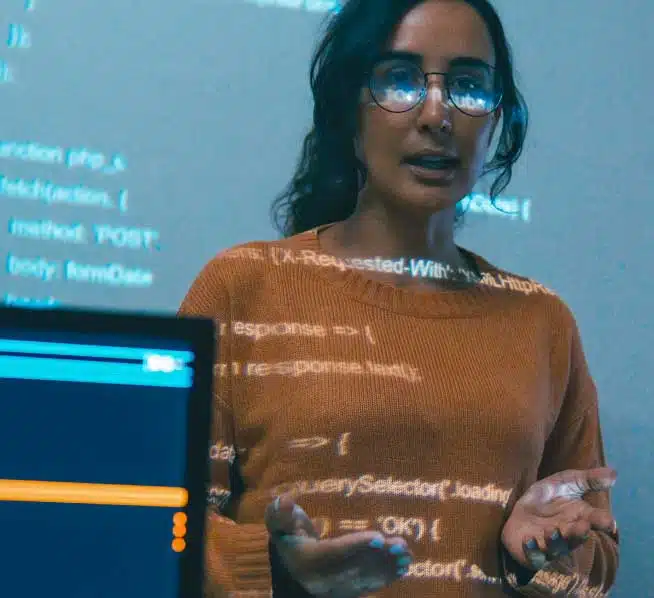 Female professor presenting code on a projector screen