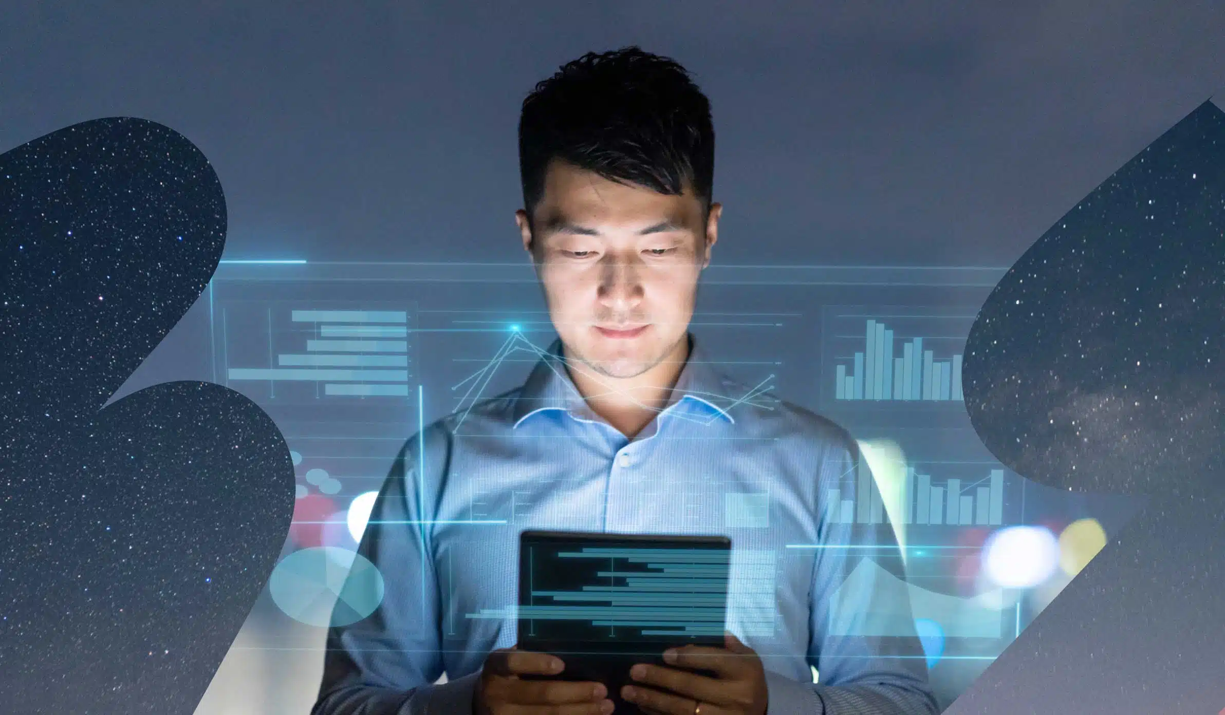 Man with short, dark hair in business casual clothing looking at his tablet screen, surrounded by graphs and charts