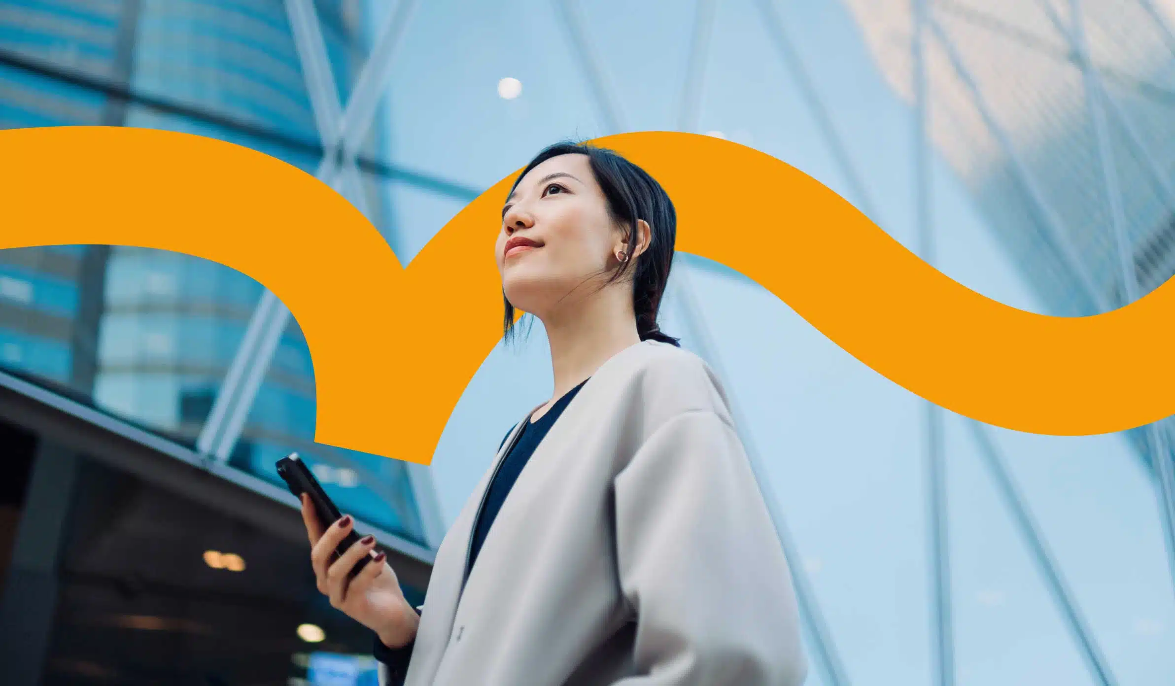 Female employee holding her phone and looking up into the air confidently