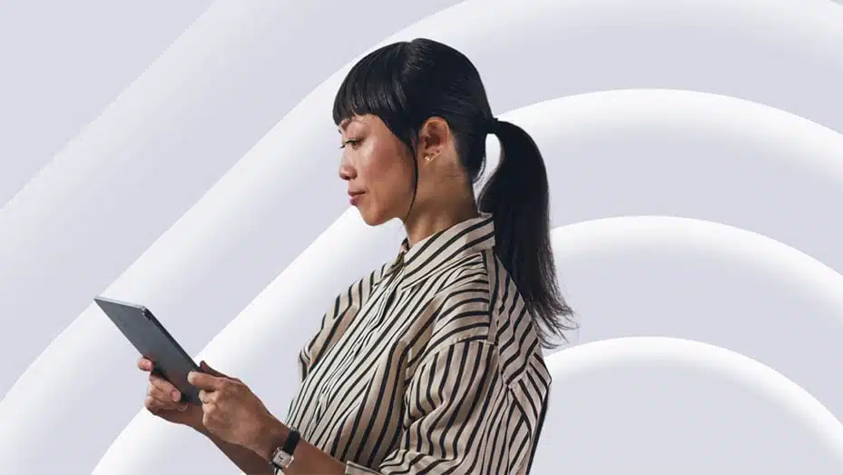 Female employee standing and looking at her tablet confidently